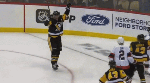 A Hockey Player Celebrates His Goal In Front Of An Ad For Ford GIF