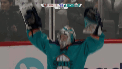 A Hockey Player Holds His Arms Up In The Air In Front Of A Scoreboard GIF