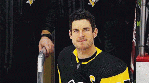 A Hockey Player In A Black And Yellow Jersey With The Letter G On The Front GIF