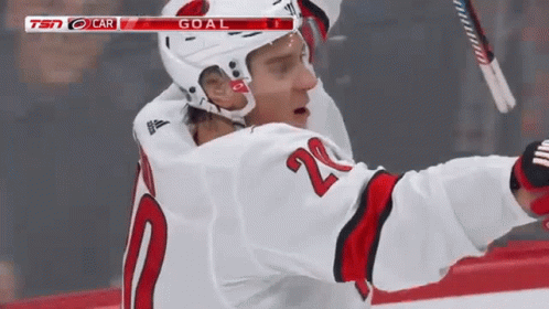 A Hockey Player In A White Jersey With The Number 20 On It GIF