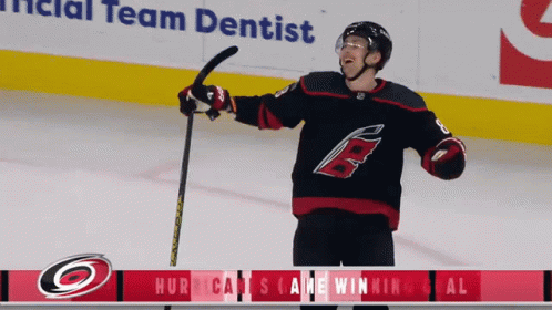 A Hockey Player Is Holding A Hockey Stick In Front Of An Ad For The Team Dentist GIF