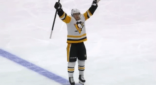 A Hockey Player Is Holding A Hockey Stick In His Hand . GIF