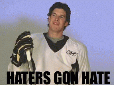A Hockey Player Is Holding A Stick With The Words Haters Gon Hate Behind Him GIF