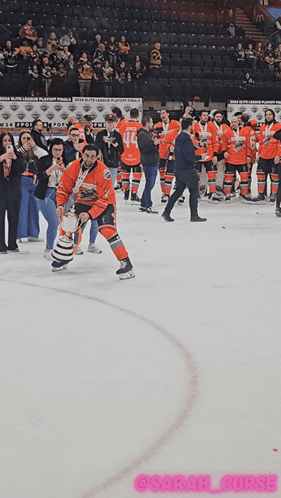 A Hockey Player Is Holding A Trophy On The Ice In Front Of A Crowd GIF