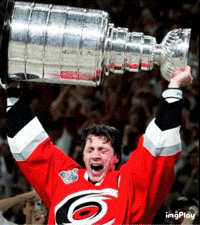 a hockey player is holding up a trophy in his hands