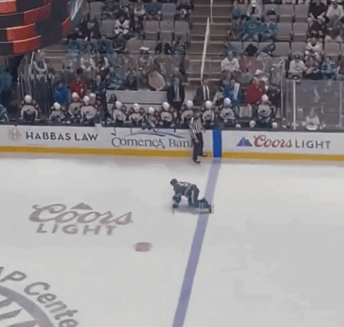 A Hockey Player Is Kneeling On The Ice In Front Of A Coors Light Advertisement GIF