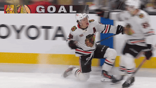 A Hockey Player Is Kneeling On The Ice In Front Of A Goal Banner GIF