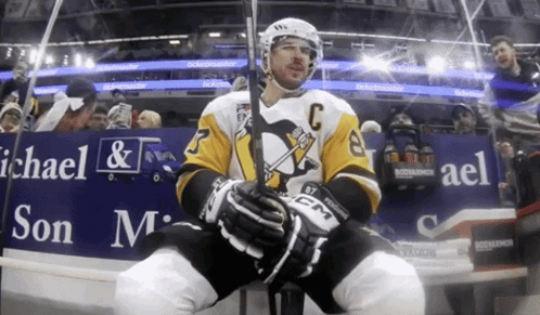 A Hockey Player Is Sitting In Front Of A Michael & Son Advertisement GIF