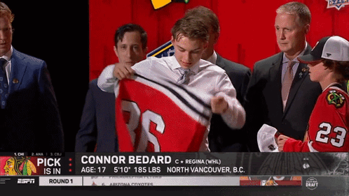 A Hockey Player Named Connor Bedard Is Being Presented With His Jersey GIF
