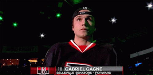 a hockey player named gabriel gagne is standing in a dark room