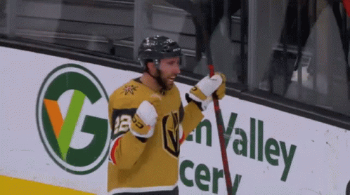A Hockey Player Stands In Front Of A Sign That Says Golden Valley GIF