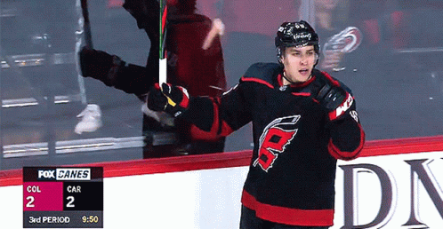 A Hockey Player Stands On The Ice With A Fox Canes Scoreboard In The Background GIF