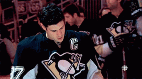 A Hockey Player Wearing A Black Jersey With The Letter C On It GIF