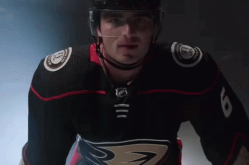 A Hockey Player Wearing A Black Jersey With The Number 8 On The Sleeve GIF
