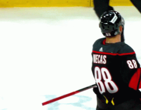 A Hockey Player Wearing A Black Jersey With The Number 88 On The Back GIF