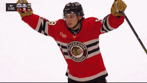 A Hockey Player Wearing A Blackhawks Jersey Is Holding A Hockey Stick GIF