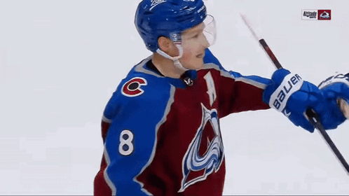 a hockey player wearing a blue helmet with the letter c on his chest