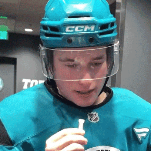 A Hockey Player Wearing A Ccm Helmet Holds A Stick GIF