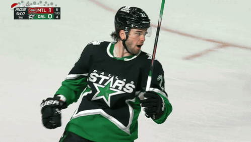 A Hockey Player Wearing A Dallas Stars Jersey Holds A Stick GIF