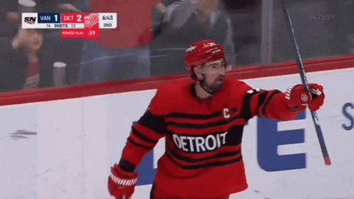 A Hockey Player Wearing A Detroit Jersey Is Holding A Hockey Stick GIF