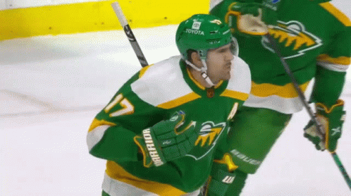 A Hockey Player Wearing A Green Jersey That Says Warrior GIF