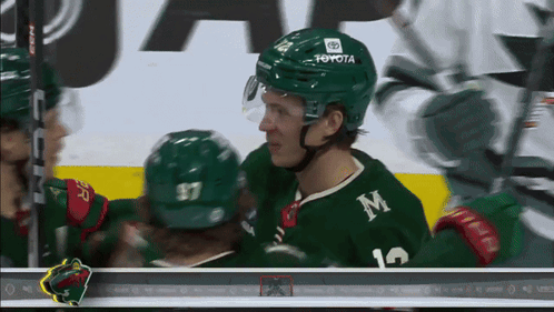 A Hockey Player Wearing A Green Jersey With The Letter M On It GIF