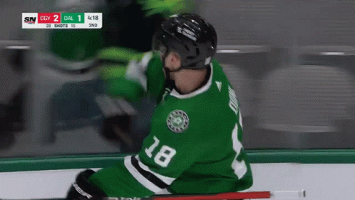 A Hockey Player Wearing A Green Jersey With The Number 18 GIF