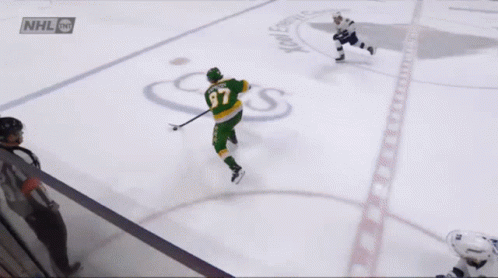 A Hockey Player Wearing A Green Jersey With The Number 37 GIF