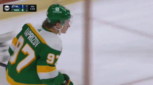 A Hockey Player Wearing A Green Jersey With The Number 97 GIF