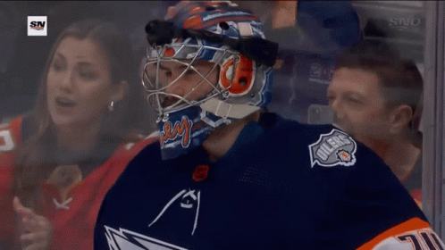 A Hockey Player Wearing A Helmet With The Word Oilers On The Front GIF