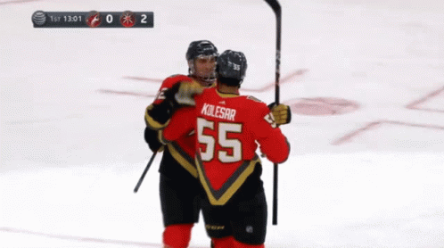 A Hockey Player Wearing A Number 55 Jersey Is Hugging Another Player GIF