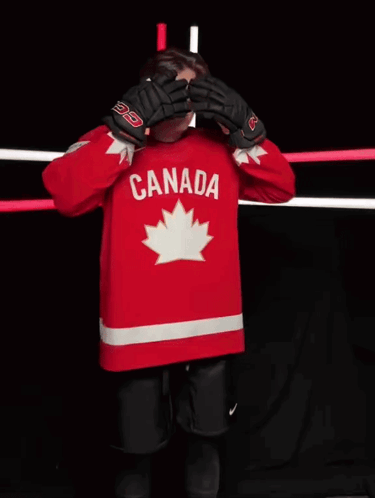A Hockey Player Wearing A Red Canada Jersey Stands In Front Of A Camera GIF