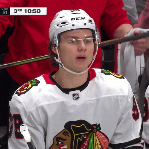 A Hockey Player Wearing A White Ccm Helmet Looks At The Camera GIF