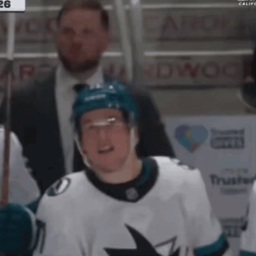 A Hockey Player Wearing A White Jersey With A Shark On The Front GIF