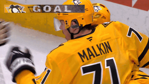 A Hockey Player Wearing A Yellow Jersey With The Name Malkin On It GIF