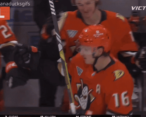 A Hockey Player With The Number 11 On His Helmet Is Hugging Another Player GIF