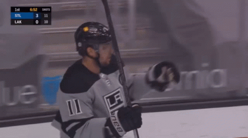 a hockey player with the number 11 on his jersey is holding a hockey stick