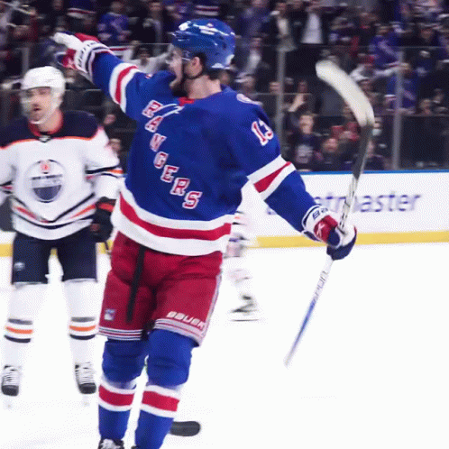 A Hockey Player With The Number 13 On His Jersey Holds Up His Stick GIF