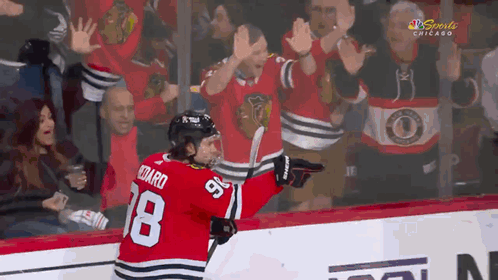 A Hockey Player With The Number 18 On His Jersey Is Celebrating GIF