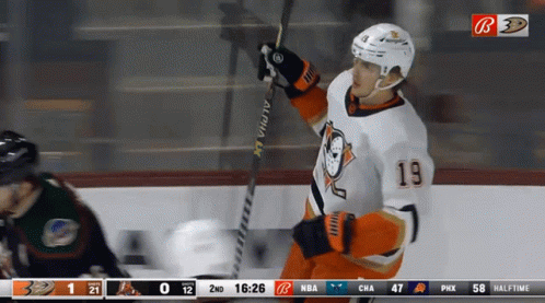 A Hockey Player With The Number 19 On His Jersey Holds A Hockey Stick GIF