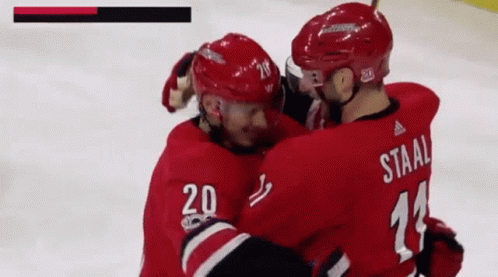 A Hockey Player With The Number 20 On His Jersey Is Hugging Another Hockey Player With The Number 11 On His Jersey GIF