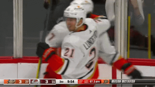 A Hockey Player With The Number 21 On His Jersey Is Being Hugged By Another Player GIF