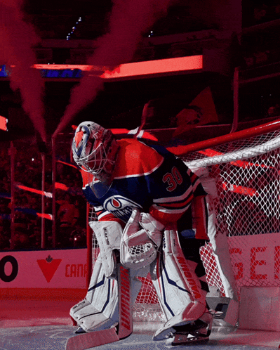 A Hockey Player With The Number 30 On His Jersey Stands In Front Of The Net GIF