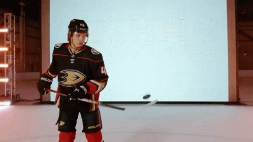 A Hockey Player With The Number 4 On His Jersey Is Holding A Hockey Stick GIF