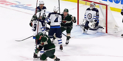 A Hockey Player With The Number 4 On His Jersey Is Surrounded By Other Players GIF