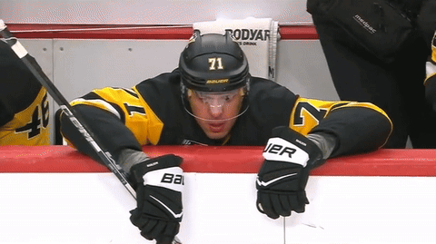 A Hockey Player With The Number 71 On His Helmet Sits On The Bench GIF
