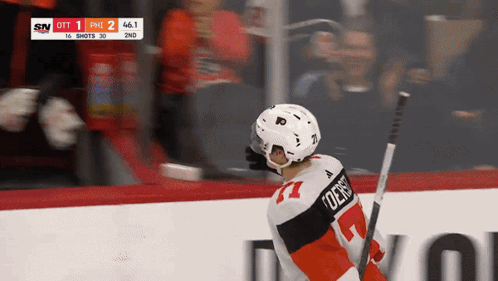 A Hockey Player With The Number 77 On His Jersey Is Holding A Hockey Stick GIF