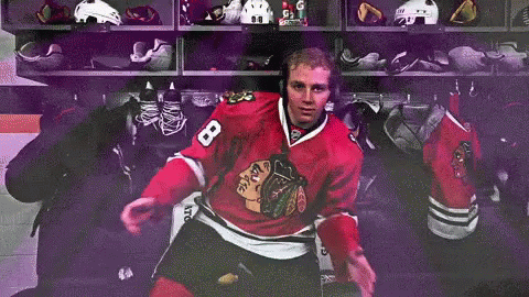 A Hockey Player With The Number 8 On His Jersey Is Sitting In A Locker Room GIF