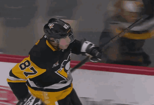 A Hockey Player With The Number 87 On His Jersey Is Holding A Hockey Stick GIF
