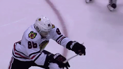 A Hockey Player With The Number 88 On His Jersey Is Holding A Hockey Stick On The Ice . GIF